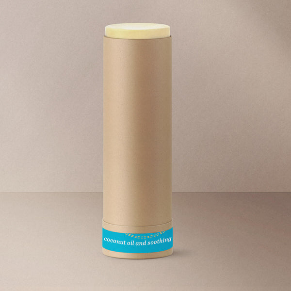 Off white paw balm in open brown paper push up tube with blue bottom label
